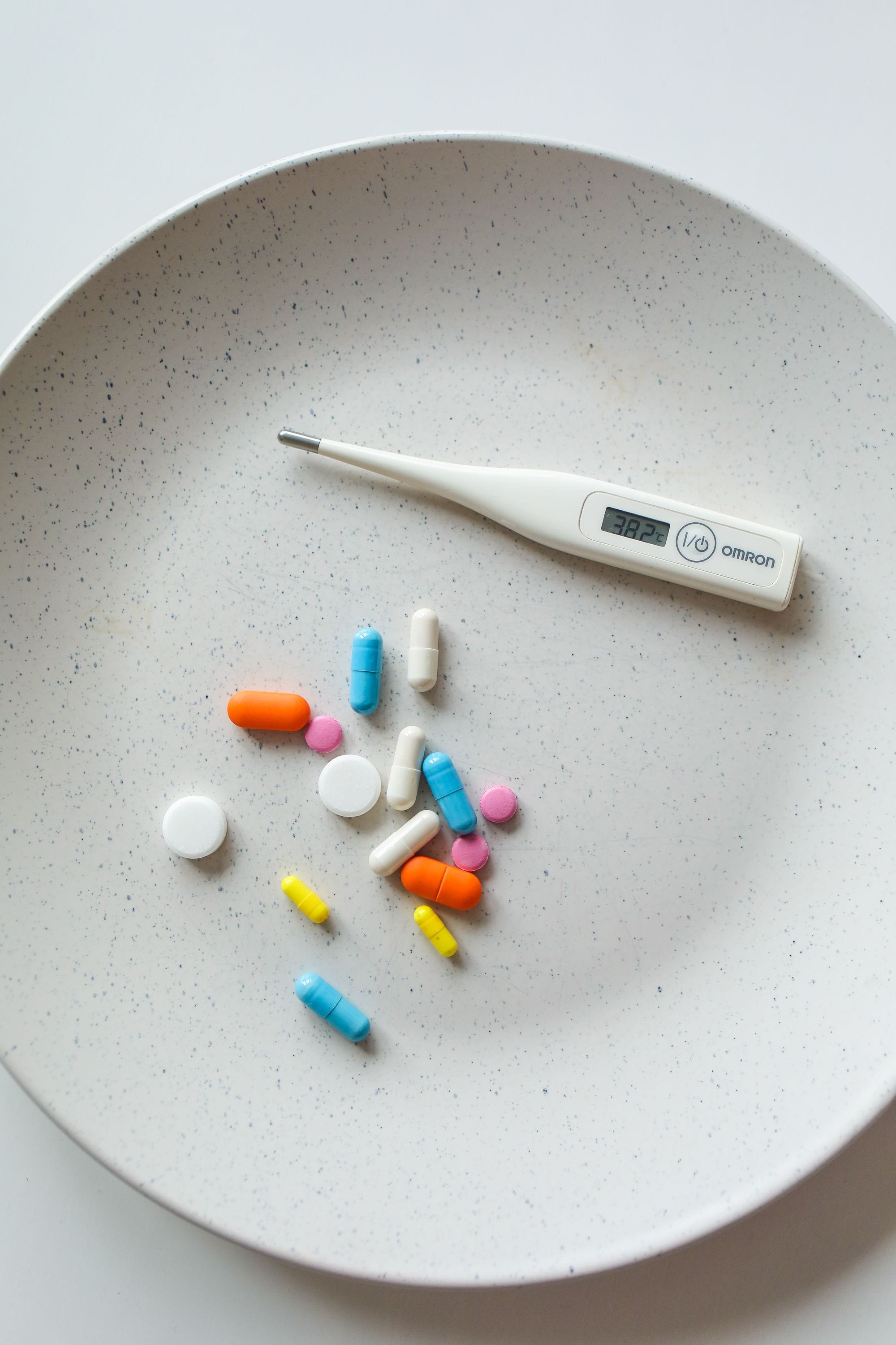 Comprimidos e um termómetro digital, simbolizando o efeito do calor sobre os medicamentos